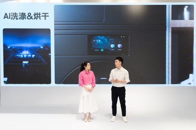 A person and person standing in front of a large screen

Des<i></i>cription automatically generated